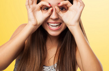 portrait of young woman doing a glasses gesture closeup